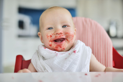 Baby isst und lacht